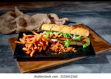 Crispy Fish Burger With Fries In A Black Dish On Cutting Board Side View On Dark Background Fast Food