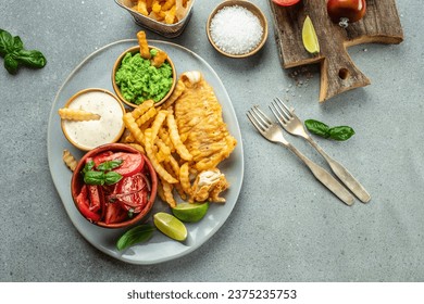 Crispy Fish and Chips served with mashed peas, vegetable salad, tartar sauce, Traditional British food, place for text, top view, - Powered by Shutterstock - Get 15% off with code: PIKWIZARD15