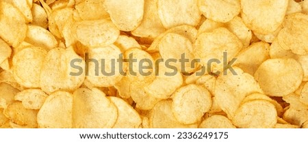 Crispy fresh potato chips, snacks background. Top view, flat lay. Banner