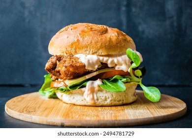 Crispy fried chicken burger served with tomatoes, leafy greens, cheese and sriracha mayo. - Powered by Shutterstock