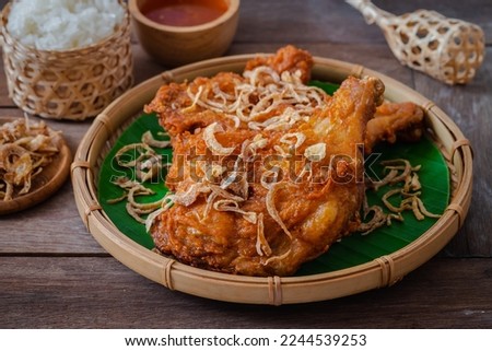 Crispy fried chicken with deep fried shallot on banana leaf in basket (Hat Yai fried chicken), Thai food style