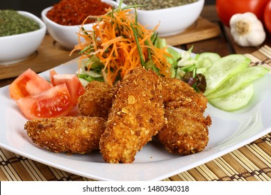 Crispy fried chicken strips and legs with french fries in basket