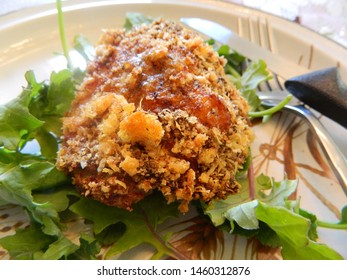crispy fried chicken thigh on a salad with fork and knife