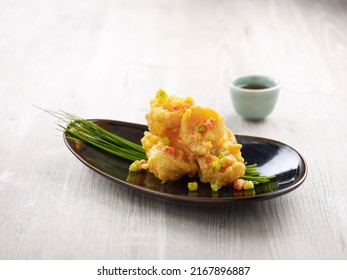 Crispy Fried Crystal Prawns Tossed With Salted Egg Yolk With Chopsticks Served In A Dish Isolated On Mat Side View On Grey Background