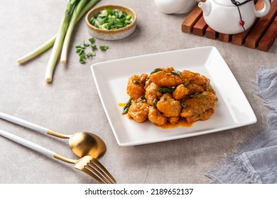 Crispy fried dori fish coated with salted egg plated on a white plate