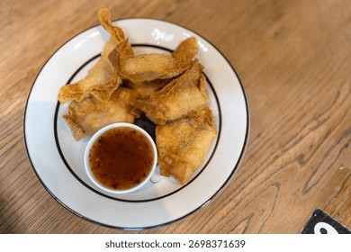 Crispy fried dumpling paste stuffed chop pork dipping sweet chili sauce on plate