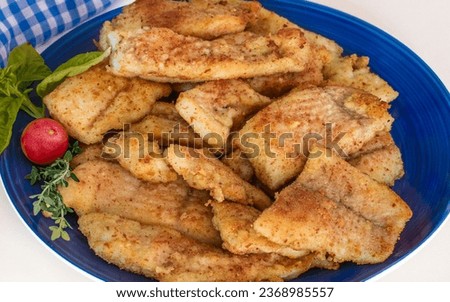 crispy fried fish pieces on o blue plate on white background, tasty, ealthy and satisfying plate.