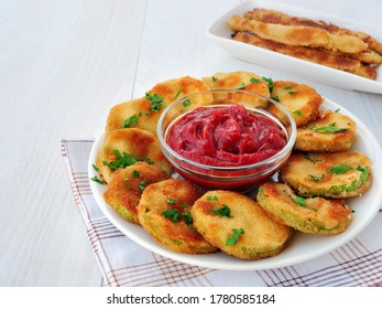 Crispy fried zucchini chips coated in breadcrumbs with a bowl of ketchup