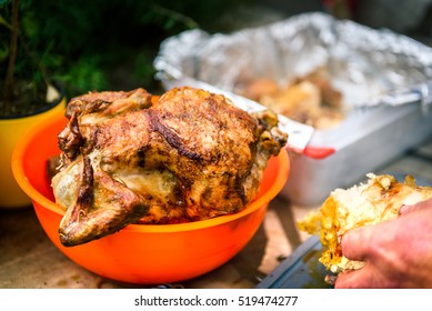 Crispy Grilled Rotisserie Chicken In Orange Bowl At Piknik Party. Whole Fried Chicken Is Waiting To Be Cut Or Sliced Outside In The Nature.