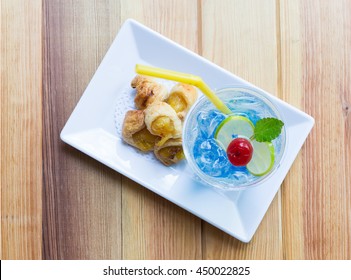 Crispy Pineapple Pie On Rectangle White Plate With Blue Juice. Top View.