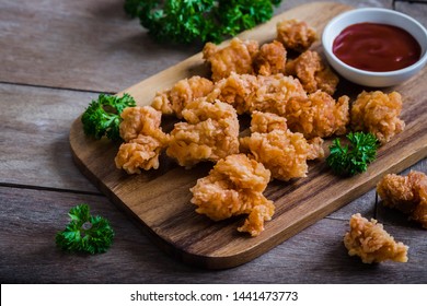 Crispy popcorn chicken on wooden board and dipping sauce