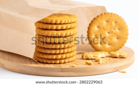 Crispy round biscuit crackers with stack and broken pieces, paper plastic takeaway bag package, wooden serving board isolated mockup.