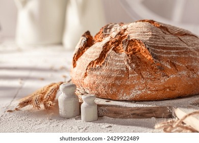 Crispy round loaf bread on wooden cutting board. Bread in the countryside. - Powered by Shutterstock