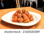 Crispy sesame chicken balls, chicken dishes with sauce eaten with chopstick Chinese dishes, stylish presentation close-up, crispy panned chicken meal, far eastern delicacies