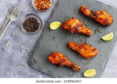 Crispy Skinned Roast Chicken Drumsticks on a Platter with Black Pepper and Chili Flakes Top Down Photo