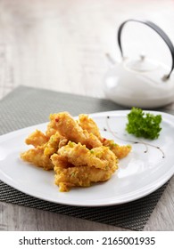 Crispy Squid Tossed With Salted Egg Yolk Served In A Dish Side View On Grey Background