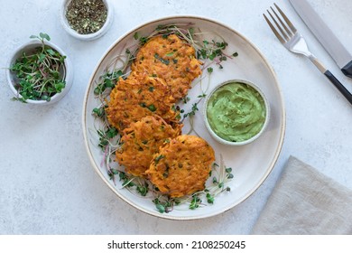 Crispy sweet potato fritters served with microgreens and creamy guacamole on ceramic plate. Vegan lunch plate. top view - Powered by Shutterstock