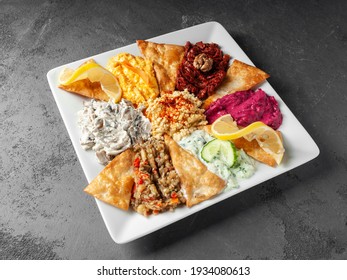 crispy tortillas chips with assorted different sauces on a white plate
