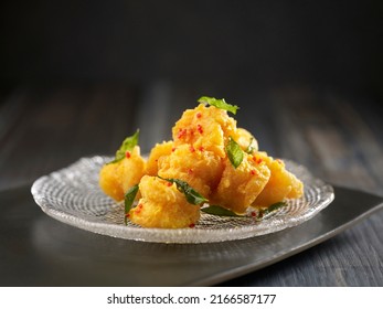 Crispy-fried Crystal Prawns With Salted Egg Yolk Served In A Dish Isolated On Cutting Board Side View On Dark Background