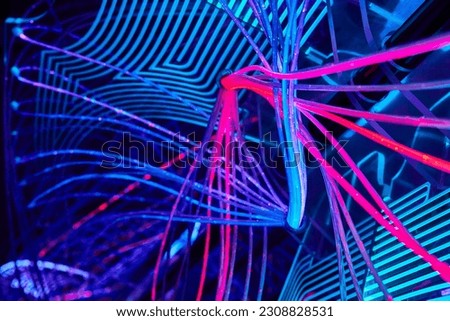 Crisscrossing web of colorful LED techno neon lights of blue pink and purple