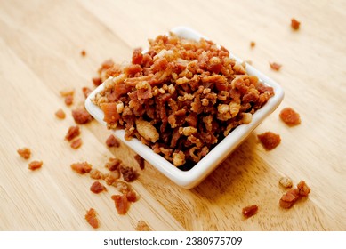 Crisy Bacon Bit Overflowing from a Square White Bowl	