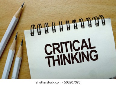 Critical thinking text written on a notebook with pencils