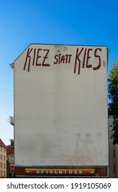 Criticism Of Capitalism In Berlin-Neukoelln: House Wall With German Slang Words 