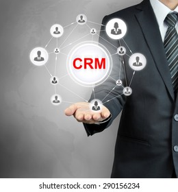 CRM (Customer Relationship Management) sign with people icons linked as network on businessman hand