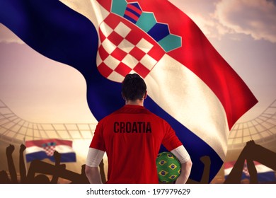 Croatia Football Player Holding Ball Against Large Football Stadium Under Bright Blue Sky