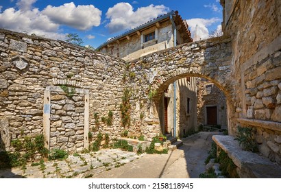 Croatia Istria. Ancient abandoned medieval town Plomin. Old stone street with ruined walls houses and stairs overgrown by ivy plants.