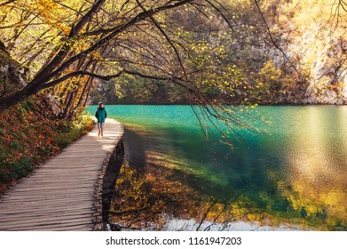 Croatia Nature Park Plitvice Lakes In Autumn - Boy Walks On Bridge Over The Lake