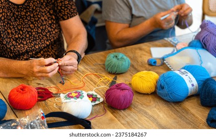 Crochet Club. Elderly women friends knitting together with colored wool.