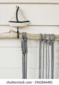 A Crochet From Grey Cotton Yarn Wall Hanging With A Boat Sculpture On It