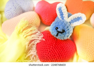 A crochet toy of a cute bunny. 
Rabbit plush toy blue color and  many craft hearts and knitted scarf  - Powered by Shutterstock