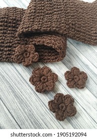 Crochet Warm Scarf And Crochet Flower On Wooden Table. Crochet With Cotton Yarn.