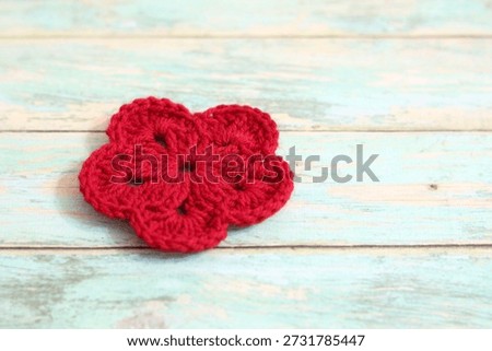 Crocheted flowers handmade craft objects on wooden background cozy home decorative handiwork hobby 
