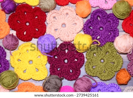 Crocheted flowers handmade craft objects on wooden background cozy home decorative handiwork hobby