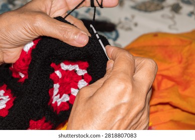 crocheting a colorful handmade patch using a crochet hook and yarn at home, traditional craftsmanship, textile artistry, and the intricate process of creating handmade crochet products