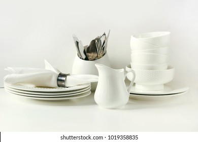 Crockery,dish, tableware, utensils and other different white stuff on white table-top. Kitchen still life as background for design. Image with copy space. - Shutterstock ID 1019358835