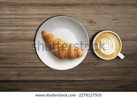 Croissant and cappucino on a table top view