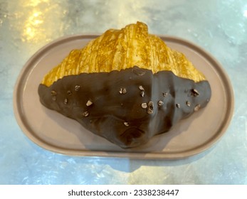 Croissant with chocolate truffles serving on pink plate - Powered by Shutterstock