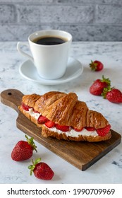 Croissant With Cream Cheese And Strawberries For Breakfast With A Cup Of Coffee.