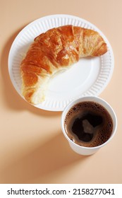 Croissant On Paper Plate And Coffee Cup On Beige Background, Top View Takeaway Food