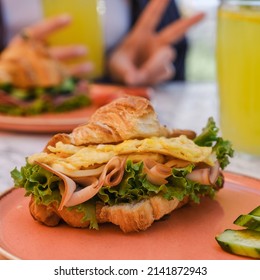 Croissant Sandwich Breakfast With Scrambled Egg, Crispy Bacon And Mashed Avocado.  