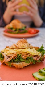 Croissant Sandwich Breakfast With Scrambled Egg, Crispy Bacon And Mashed Avocado.  