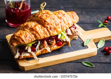 Croissant Sandwich With Duck Meat, Cream Cheese And Cranberry Sauce On Board, Dark Background.