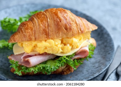 Croissant sandwich with egg and ham on a plate, closeup view. Tasty sandwich - Powered by Shutterstock