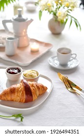 A Croissant Served With Butter And Jam, A Cup Of Espresso, A Coffee Can, A Candle, A Milk Can And A Plant In The Backdrop, Shallow Dept Of Fields, Bokeh