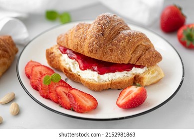 croissant with strawberry jam and cream cheese on a white plate, close-up - Powered by Shutterstock