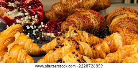 croissants with cream and brioche and a pomegranate in the background in the pastry shop